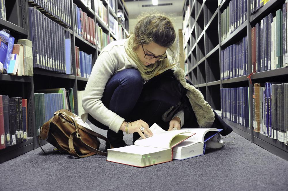 Student sitting on the floor of the SOAS library reading
