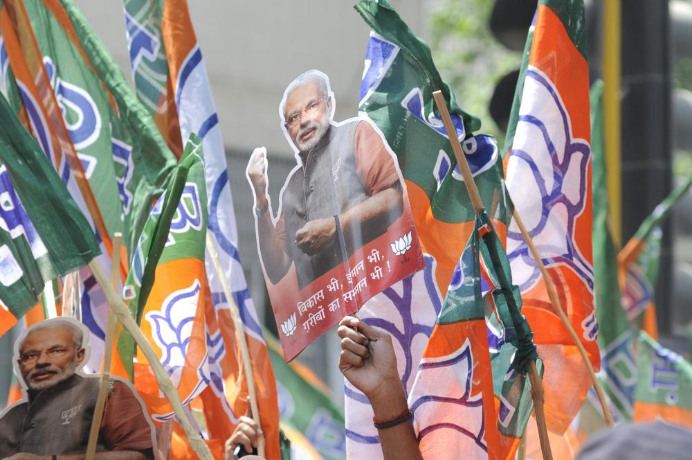  A man waiving a Narendra Modi cut out during a rally