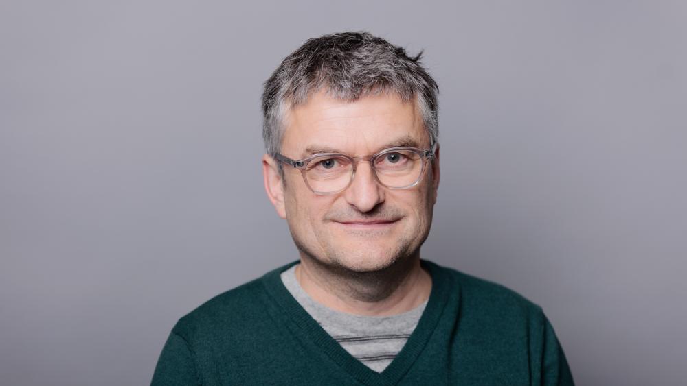 Headshot of Neil Armstrong with a grey background