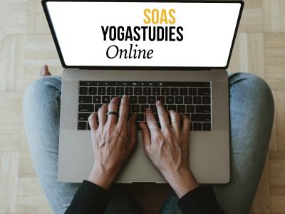 A student seated crosslegged with a laptop accessing SOAS YogaStudies Online website.