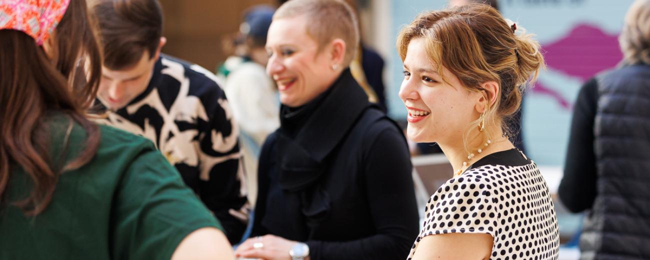 Group of four people gathered, talking and smiling