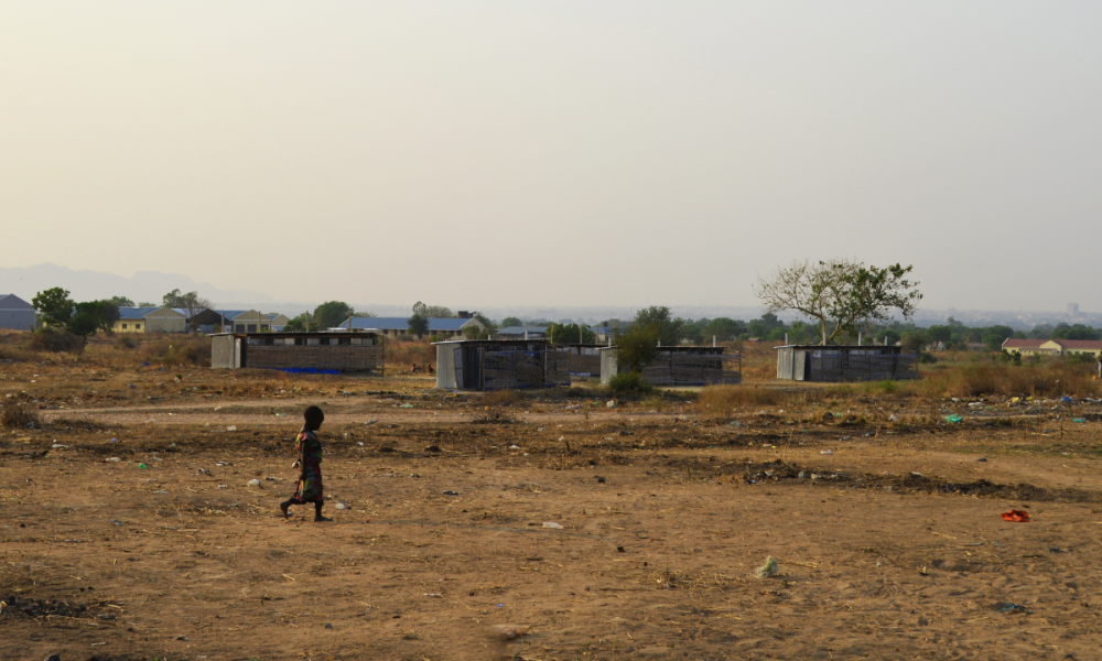 Silhouette of a child walking a camp in Sudan.png