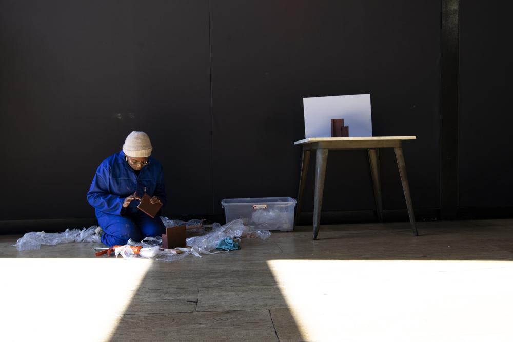 An architect setting up an exhibition in a gallery
