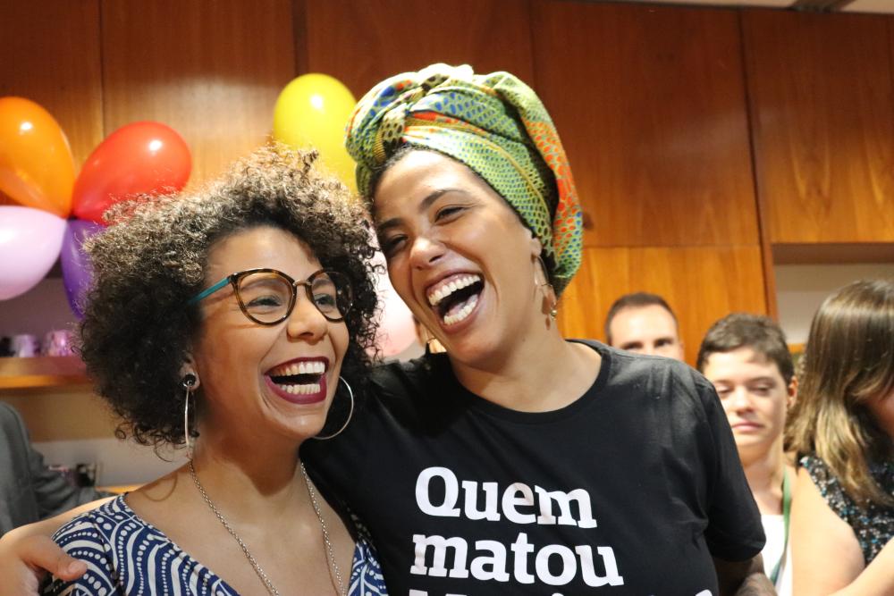 Two members from the Brazilian Chamber of Deputies smiling and laughing together