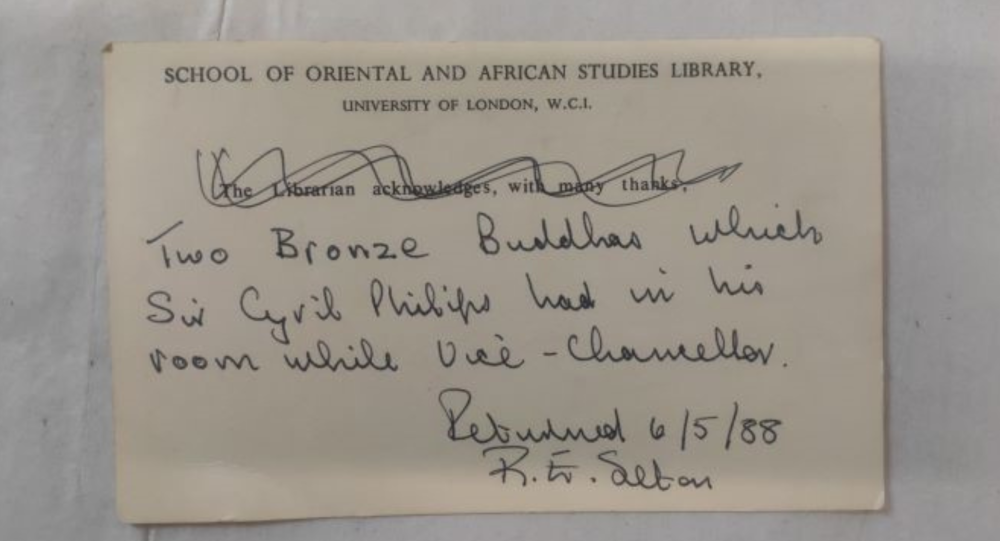 A note from 1988 that says 'Two Bronze Buddhas which Sir Cyril Phillips had in his room while Vice-Chancellor'