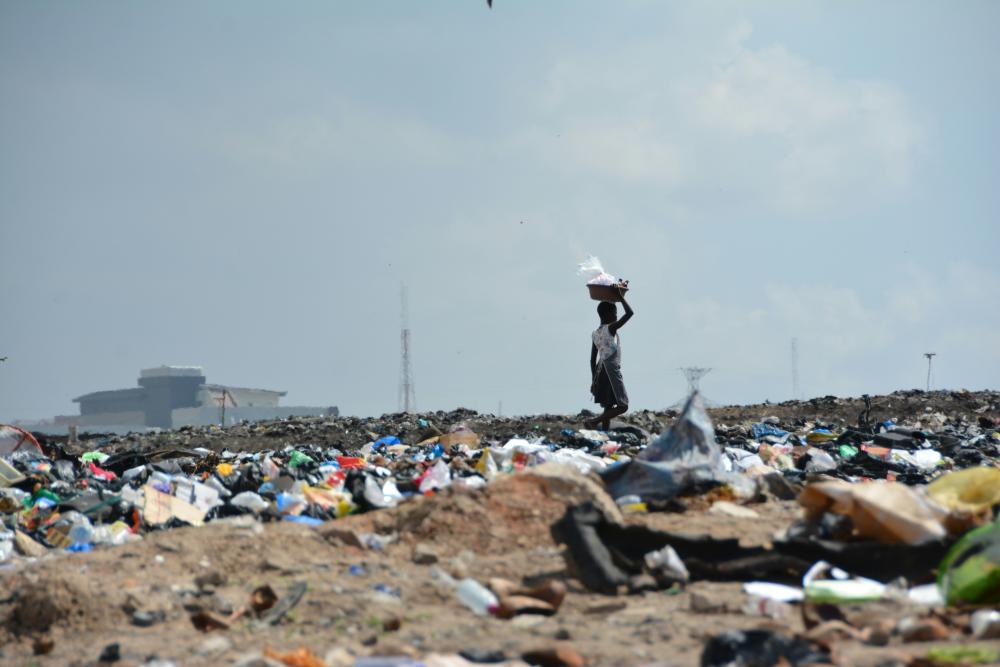 A person walks through a landfill site