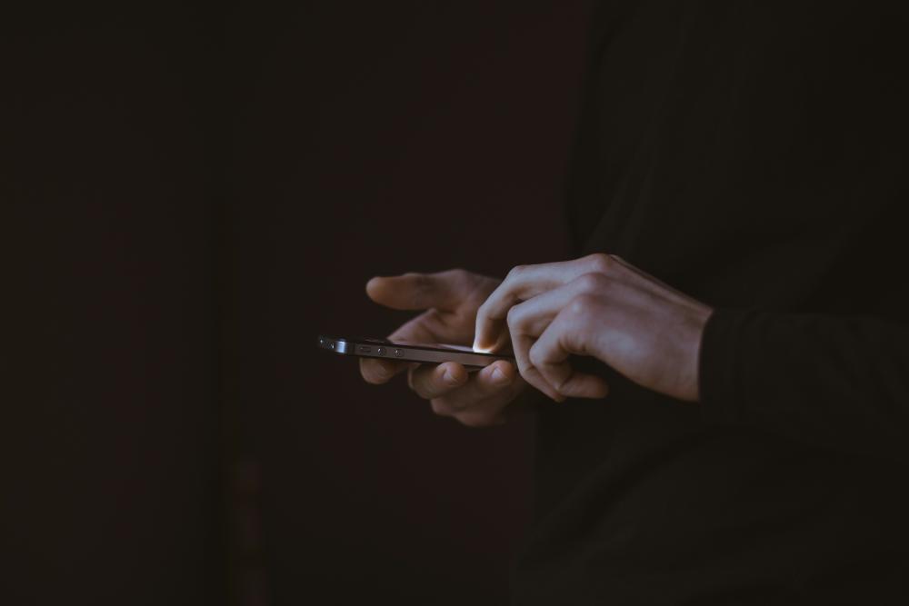 Person holding phone with black background