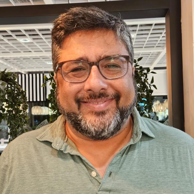 Front facing photo of a man with glasses smiling