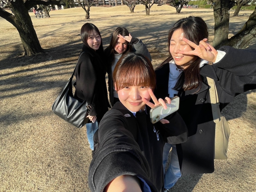 A group of four women smile and pose at the camera 