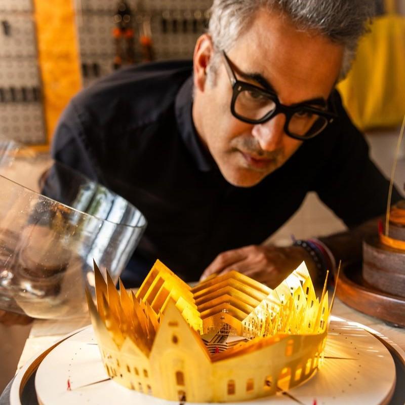 Photograph of Karl Singporewala looking at one of his sculptures