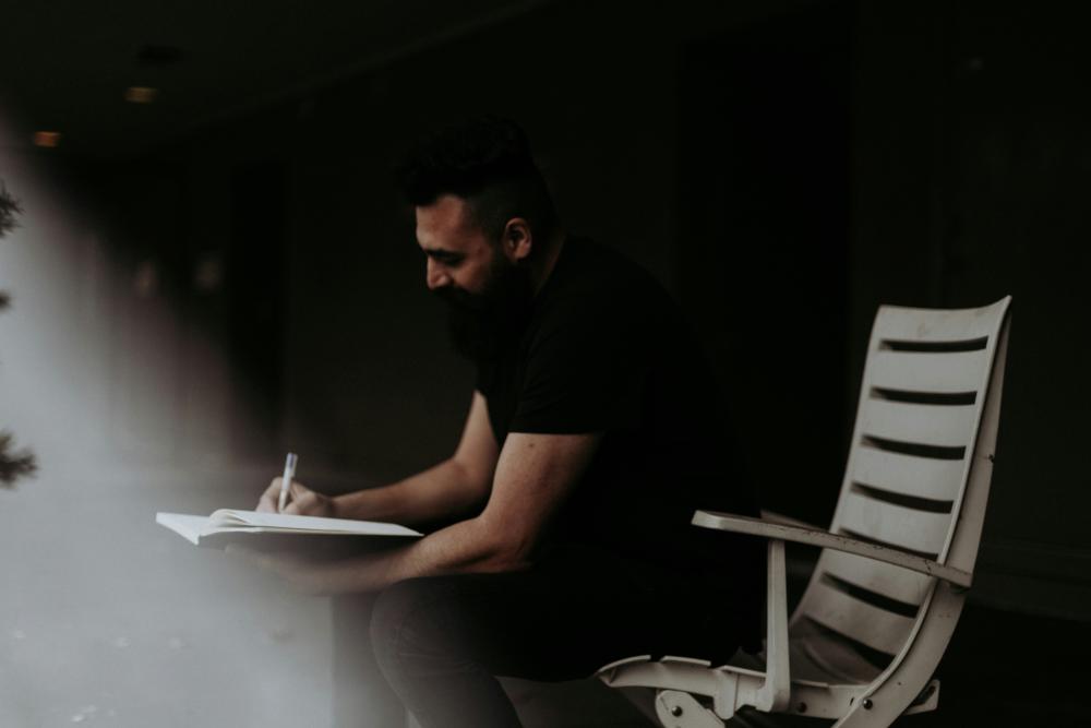 Man sitting and writing in journal