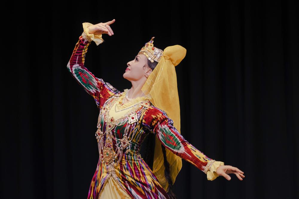 woman dancing with one arm raised and one arm lowered.