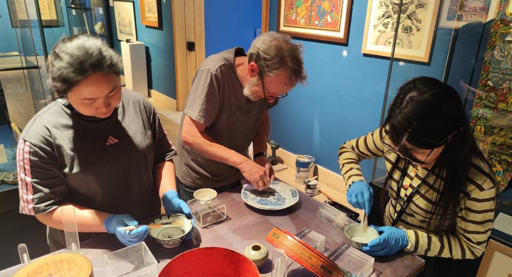 Preparing the Vietnamese blue-and-white ceramics for display.