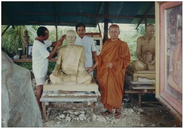 Pha Ouan Sanith Aphakaro poses next to a likeness of the last Supreme Patriarch of the Kingdom of Laos being sculpted in Udon Thani, Thailand. Maha Samarn Khemiko, 1990. Collection of Vat Saen Sukharam, Buddhist Archives of Luang Prabang, B-8958.