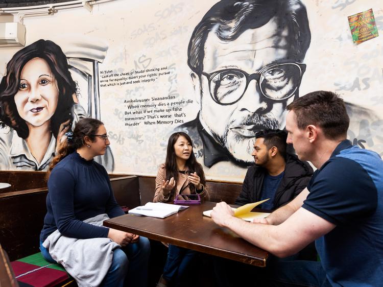 Students in front of murals in SU bar
